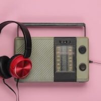 https://bricartsmedia.org/wp-content/uploads/2025/08/retro-radio-receiver-oldfashioned-wired-headphones-pink-pastel-background-1-min.jpg